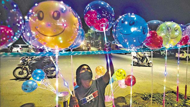 A balloon seller arranges balloons decorated with LED lights at Mutha riverbed road on new year's eve in Pune, India.(Pratham Gokhale/HT Photo)