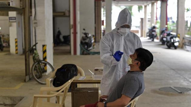 A healthcare worker during Covid-19 screening and swab test at Malad (West) in Mumbai, on Sunday.(Satyabrata Tripathy/HT Photo) A healthcare worker during Covid-19 screening and swab test at Malad (West) in Mumbai, on Sunday.(Satyabrata Tripathy/HT Photo)