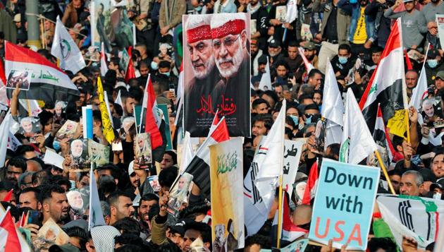 Iraqis hold placards and flags as they gather to mark the one year anniversary of the killing of Qassem Soleimani.(REUTERS)