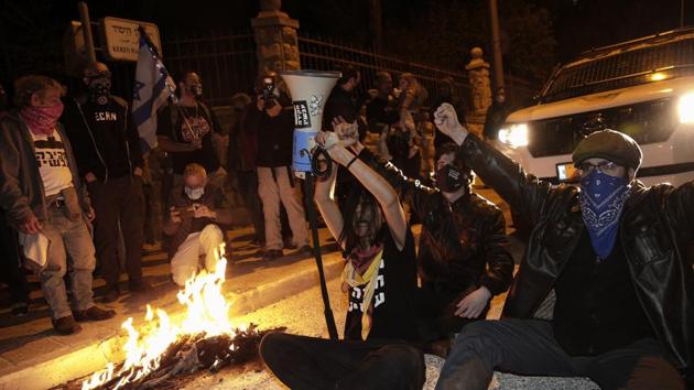 Israeli protesters chant slogans and block a road during a demonstration against Israeli Prime Minister Benjamin Netanyahu near his official residence in Jerusalem. (AP) Israeli protesters chant slogans and block a road during a demonstration against Israeli Prime Minister Benjamin Netanyahu near his official residence in Jerusalem. (AP)