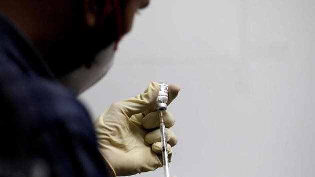 A medic fills a syringe with Covxin before administering it to a health worker during its trials, at the Gujarat Medical Education and Research Society in Ahmedabad, India.