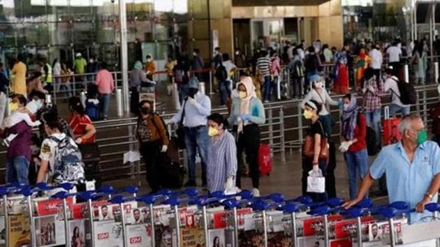 An airport staff member pushes trolleys at the entrance of Mumbai's airport in this file photo.(Reuters Photo) An airport staff member pushes trolleys at the entrance of Mumbai's airport in this file photo.(Reuters Photo)