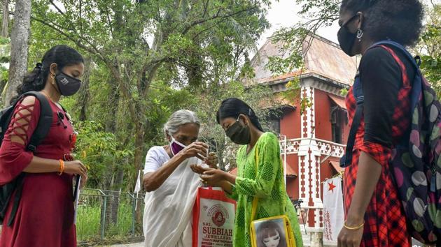 Thiruvananthapuram: An elderly woman pumps sanitizer on the hands of students before entering the premises of a university.(PTI) Thiruvananthapuram: An elderly woman pumps sanitizer on the hands of students before entering the premises of a university.(PTI)