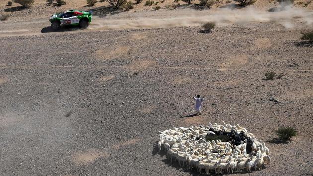 Yasir Seaidan of Saudi Arabia and co-driver Alexy Kuzmich of Russia zip past a shepherd during Stage 1 of the 2021 Dakar Rally on January 3. (Franck Fife / AFP)