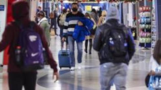 Travelers wearing protective masks walk through LaGuardia Airport in New York, US.(Bloomberg) Travelers wearing protective masks walk through LaGuardia Airport in New York, US.(Bloomberg)