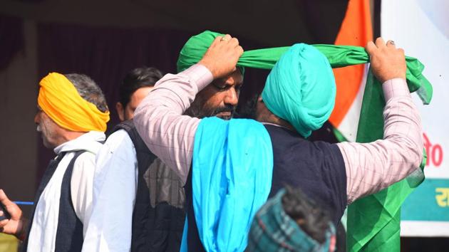 A demonstrator helps another tie a turban during the ongoing sit-in protest against new farm laws, at Ghazipur border in New Delhi, India, on Monday, January 4, 2021. (Photo by Raj K Raj/ Hindustan Times) A demonstrator helps another tie a turban during the ongoing sit-in protest against new farm laws, at Ghazipur border in New Delhi, India, on Monday, January 4, 2021. (Photo by Raj K Raj/ Hindustan Times)