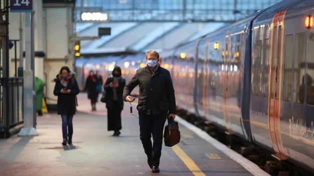 People walk next to a train at Waterloo station during morning rush hour, amid the coronavirus outbreak, in London, Britain, on January 5, 2021.