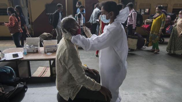 A health worker collects a swab sample from a traveller at Dadar station in Mumbai on January 4. Meanwhile, 20 more people tested positive for the new UK variant of Covid-19 on January 5, the total number of UK returnees having tested positive for the virus variant in India has reached 58. (Pratik Chorge / HT Photo) 