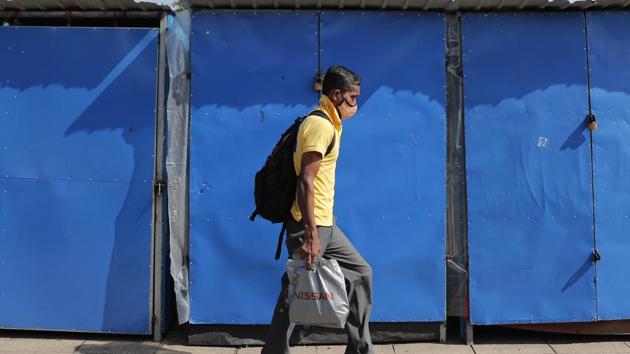 A Sri Lankan man walks past pavement shops closed due to the virus outbreak in Colombo, Sri Lanka.(AP)