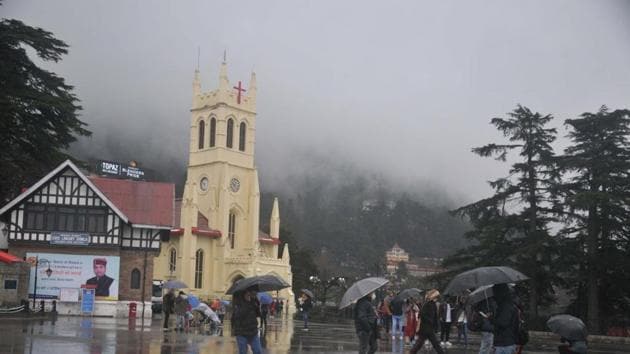 Tourists flocked to Shimla’s Ridge on Wednesday, hoping to find snow but they had to contend with a rainy and windy morning.(Deepak Sansta/HT)