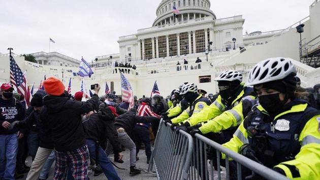 Trump supporters try to break through a police barrier at the Capitol in Washington.(AP)