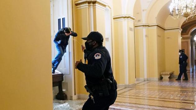 A US Capitol police officer shoots pepper spray at a protestor attempting to enter the Capitol building during a joint session of Congress to certify the 2020 election results on January 6. Reuters reported four deaths in the chaos - one from gunshot wounds and three from medical emergencies. At least 52 people were arrested according to police. (Kevin Dietsch / Pool via REUTERS) A US Capitol police officer shoots pepper spray at a protestor attempting to enter the Capitol building during a joint session of Congress to certify the 2020 election results on January 6. Reuters reported four deaths in the chaos - one from gunshot wounds and three from medical emergencies. At least 52 people were arrested according to police. (Kevin Dietsch / Pool via REUTERS)