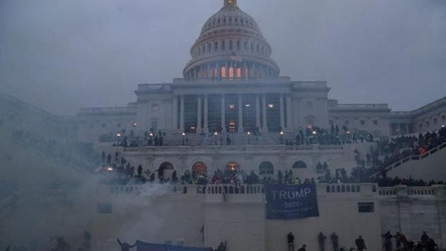 Police officers stand guard as supporters of Donald Trump gather in front of the US Capitol building in Washington, on Wednesday. (Reuters Photo)