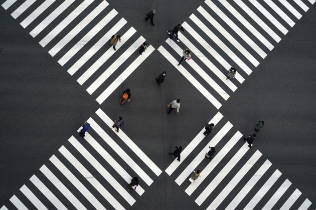 A thin crowd walks across pedestrian crossings in the Ginza shopping area of Tokyo, Japan on January 8. Japanese Prime Minister Yoshihide Suga has declared a state of emergency in Tokyo and three adjoining prefectures, after Covid-19 infections and the number of people in serious condition reached record levels. The measure has been imposed from January 8 to February 7. (Eugene Hoshiko / AP) A thin crowd walks across pedestrian crossings in the Ginza shopping area of Tokyo, Japan on January 8. Japanese Prime Minister Yoshihide Suga has declared a state of emergency in Tokyo and three adjoining prefectures, after Covid-19 infections and the number of people in serious condition reached record levels. The measure has been imposed from January 8 to February 7. (Eugene Hoshiko / AP)