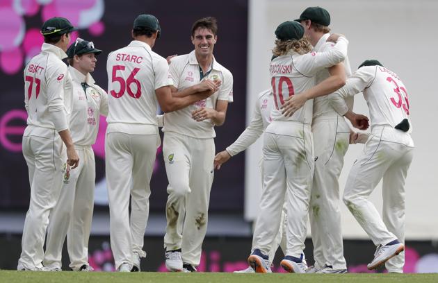 Australia's Pat Cummins, centre, is congratulated by teammates after dismissing India's Shubman Gill for 50 runs during play on day two of the third cricket test between India and Australia at the Sydney Cricket Ground, Sydney, Australia, Friday, Jan. 8, 2021. (AP Photo/Rick Rycroft) (AP)