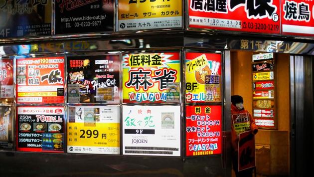 A staff member of a Japanese Izakaya pub stands to attract customers at Kabukicho district in Tokyo on January 7. The emergency Japan enacted last spring began with a declaration for seven prefectures. That was later expanded nationwide, and the duration extended, before being lifted in stages toward the end of May. (Issei Kato / REUTERS) A staff member of a Japanese Izakaya pub stands to attract customers at Kabukicho district in Tokyo on January 7. The emergency Japan enacted last spring began with a declaration for seven prefectures. That was later expanded nationwide, and the duration extended, before being lifted in stages toward the end of May. (Issei Kato / REUTERS)