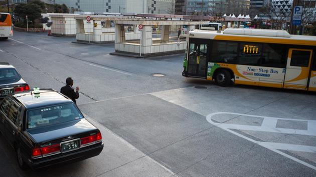 A taxi driver leans against his vehicle on an empty street in Tokyo on January 8. The main effect of the emergency will be to increase the powers of prefectural governors. Under an emergency, a governor can urge local people to avoid unnecessary outings, but residents have the right to ignore such requests, and there are no penalties for disobedience. (Kentaro Takahashi / Bloomberg) A taxi driver leans against his vehicle on an empty street in Tokyo on January 8. The main effect of the emergency will be to increase the powers of prefectural governors. Under an emergency, a governor can urge local people to avoid unnecessary outings, but residents have the right to ignore such requests, and there are no penalties for disobedience. (Kentaro Takahashi / Bloomberg)
