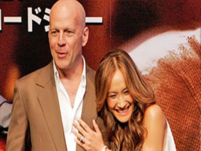 Bruce Willis and co-star Maggie Q share a joke in a photo session of their latest film Die Hard 4.