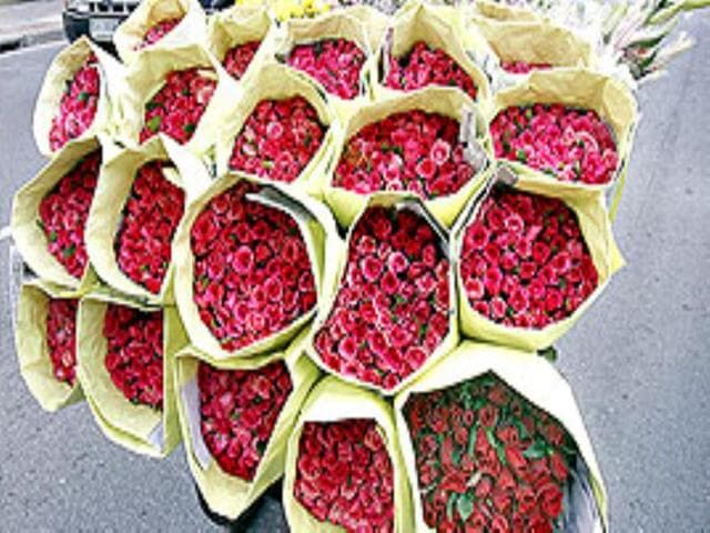 Roses and other flowers being carted on a rickshaw along a street in downtown Bangkok.