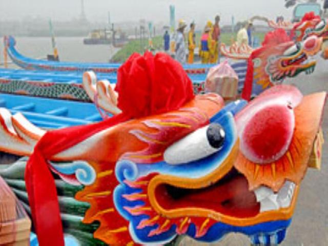 Brightly coloured, long, narrow elaborately-carved dragon-headed wooden boats are lined up in Taipei.