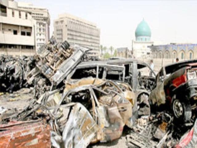 An Iraqi boy inspects wrecked cars next to Al-Kholani mosque early on Wednesday morning.