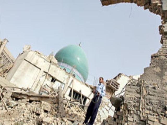 An Iraqi policeman stands amidst the rubble at the Al-Kholani Mosque on Wednesday morning.