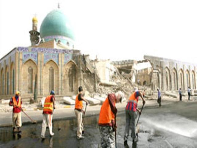 Iraqi municipality workers clean the street in front Al-Kholani mosque on early Wednesday morning.