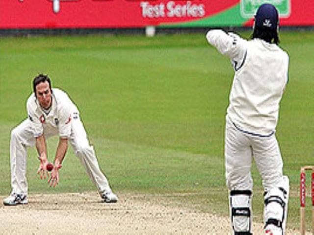Vaughan stoops to catch a return shot from Dhoni.
