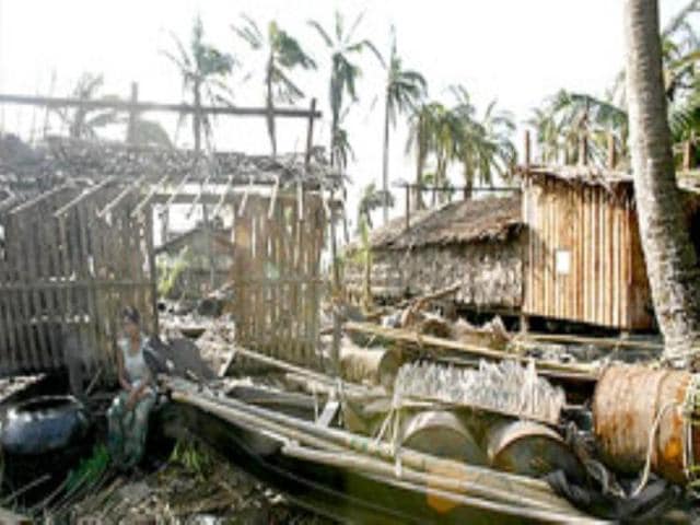Cyclone havoc: A villager sits outside her damaged house in Myanmar's village of U Khai-Hlaing.