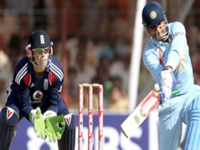 England cricketer Matt Prior (L) looks on as Indian batsman Virender Sehwag plays a shot during the first ODI between India and England in Rajkot.