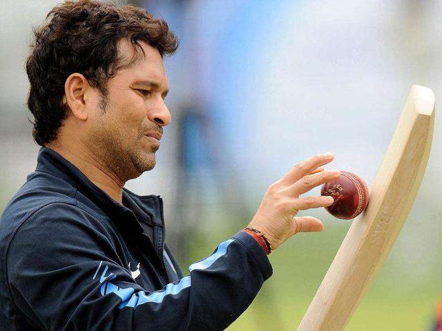 Sachin Tendulkar throws a ball against a bat during a training session before the first cricket test match against England at Lord's cricket ground in London.