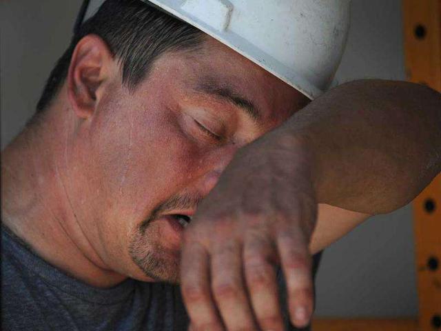 John Kramer wipes away perspiration while working on the construction site for a new Jimmy John's in St. Paul, Minn.