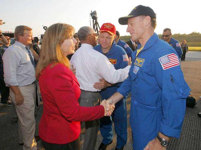 Space shuttle Atlantis mission commander Chris Ferguson (R) is greeted by Nasa deputy administrator Lori Garver after landing at the Kennedy Space Center in Cape Canaveral, Florida.