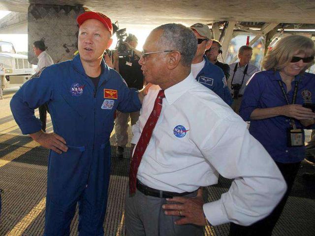 Nasa administrator Charles Bolden, right, and pilot Doug Hurley speak while walking under Space Shuttle Atlantis after landing at the Kennedy Space Center at Cape Canaveral.