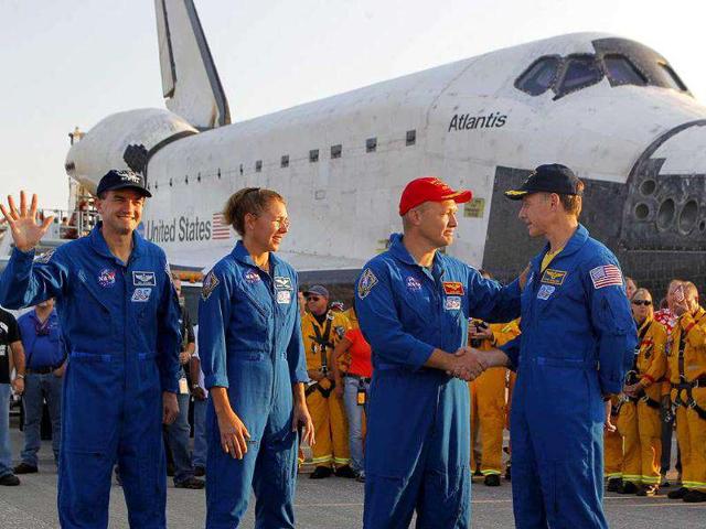 Commander Chris Ferguson, right, shakes hands with pilot Doug Hurley after landing Space Shuttle Atlantis at the Kennedy Space Center at Cape Canaveral, Florida. The landing of Atlantis marks the end of Nasa's 30 year space shuttle program.