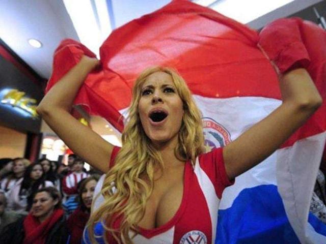 A supporter of the Paraguayan national football team watches, at a shopping center in Asuncion, the Copa America semifinal match against Venezuela taking place in Mendoza, Argentina. A supporter of the Paraguayan national football team watches, at a shopping center in Asuncion, the Copa America semifinal match against Venezuela taking place in Mendoza, Argentina.