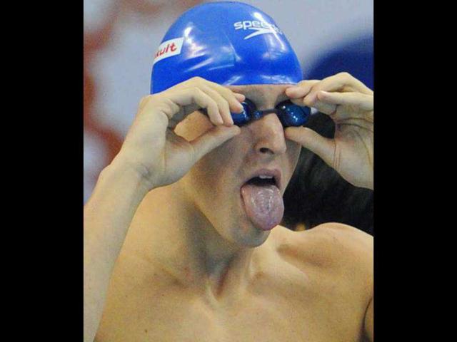 Britain's Adam Brown adjusts his glasses as he competes in the heats of the men's 4x100-metre freestyle swimming event in the FINA World Championships at the indoor stadium of the Oriental Sports Center, in Shanghai.