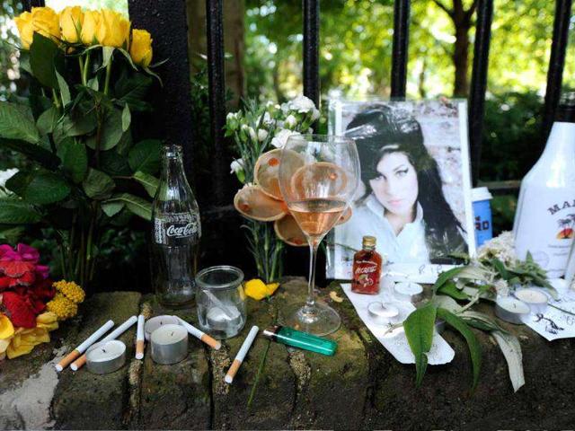Cigarettes, alcohol and photos are left with flowers and messages near the house in north London where the body of pop star Amy Winehouse was found.