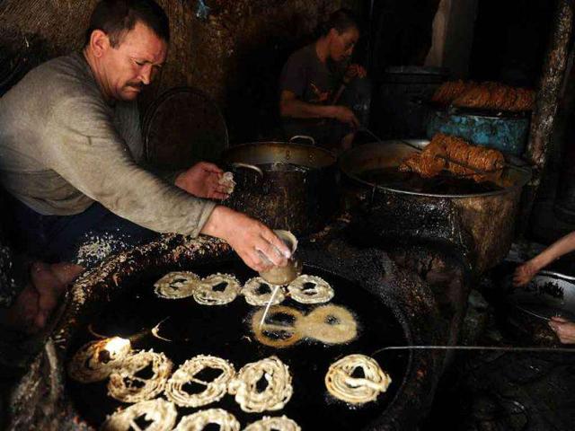 Afghan men make sweets in a shop in Kabul on the eve of the start of the Islamic holy month of Ramadan.