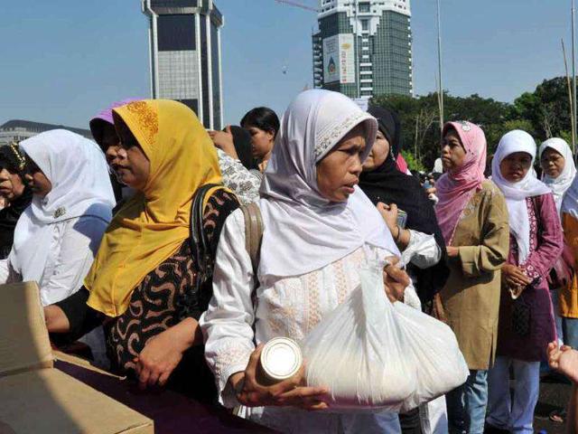 Indonesians queue to buy subsidized groceries a day before the month of Ramadan.