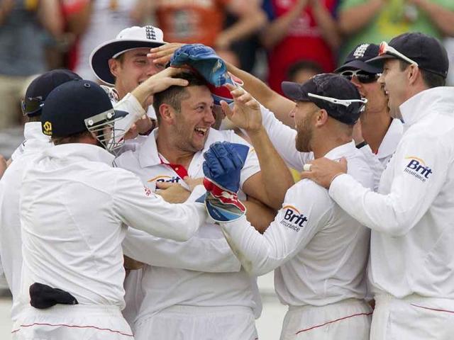 England's Tim Bresnan celebrates taking the wicket of Suresh Raina with Andrew Strauss and Graeme Swann during the fourth day of the second cricket Test match at Trent Bridge in Nottingham.
