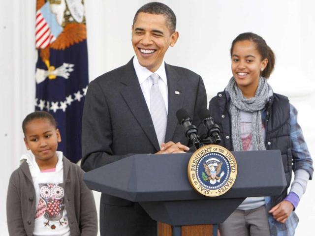 A file image of US President Brack Obama with daughters Malia and Sasha before pardoning the National Thanksgiving Turkey, Courage in a ceremony at the North Portico of the White House in Washington.