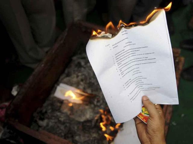 A supporter of anti-corruption activist Anna Hazare burns a copy of the Lokpal Bill during a protest on the outskirts of New Delhi