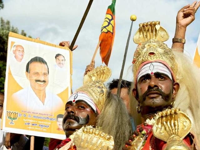 Traditional dancers of Karnataka state dressed in traditional costumes dance alongside a poster of newly appointed Chief Minister of Karnataka D V Sadananda Gowda in Bangalore. Sadananda Gowda was sworn in to replace ex chief minister B S Yeddyurappa had who resigned on July 31 after he was accused of being in the center of a $3.6 billion mining fraud.