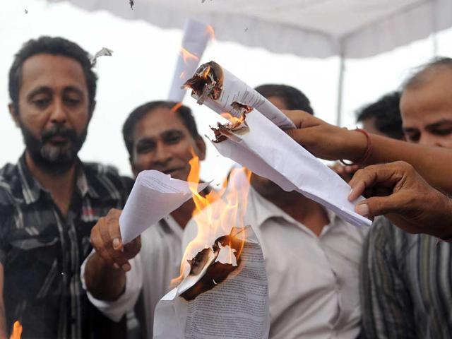 Supporters of anti-corruption activist Anna Hazare burn copies of the lokpal bill during a protest on the outskirts of New Delhi.
