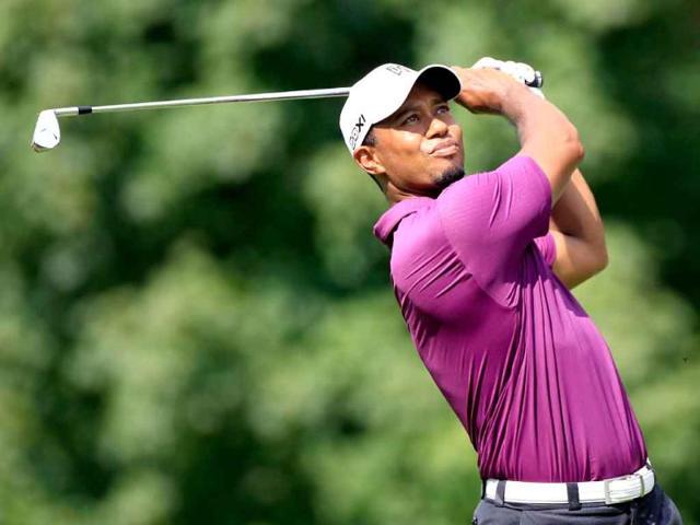 Tiger Woods hits his second shot during the first round of the World Golf Championships-Bridgestone Invitational on the South Course at Firestone Country Club in Akron, Ohio.