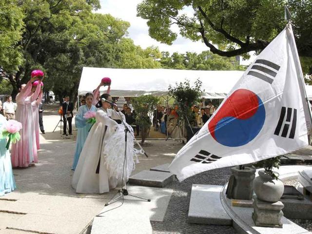 South Korean residents in Japan dance in front of the cenotaph for Korean atomic bomb victims at the Peace Memorial Park in Hiroshima, western Japan.
