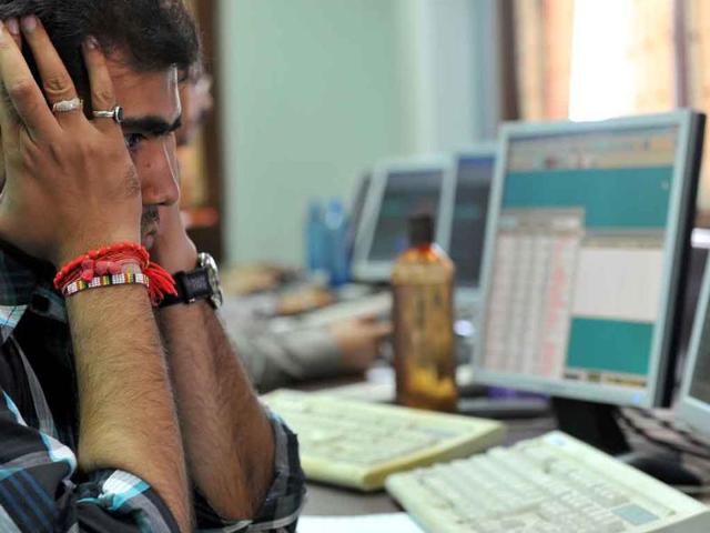 A stockbroker reacts as he monitors share prices during intraday trade at a brokerage firm in Mumbai