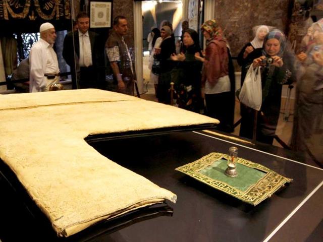 Visitors stand next to the "Hirka-i Serif", or Holy Cloak, as it is exhibited at the 18th-century Hirka-i Serif mosque in Istanbul. The cloak is unearthed for exhibition every year on the first Friday of Ramadan untill the end of the holy month in this mosque. The mosque was built by Sultan Abdulmecit in 1851 for the preservation of the cloak, which Muslims believe was handed over to Uvayis Al-Karani by Prophet Mohammad.