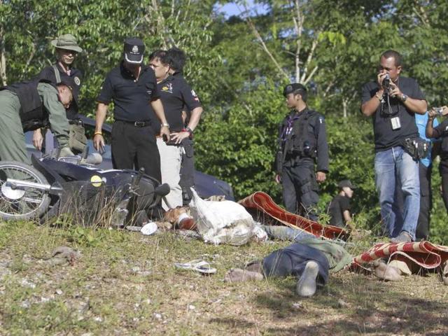 Thai police inspect dead bodies in southern Thailand's Pattani province. Suspected separatists shot dead three Buddhists in Thailand's rebellious Muslim south, police said.
